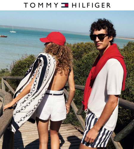 young man and woman walking down to beach with towels