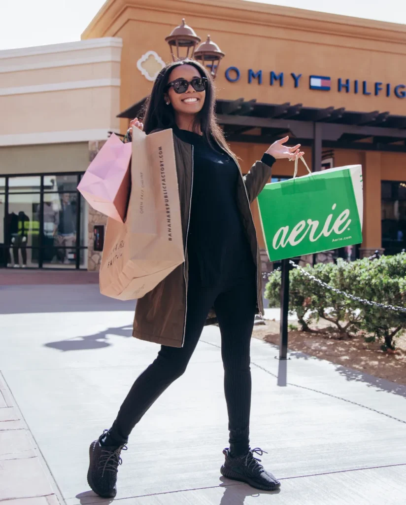 Woman Smiling While Carrying Shopping Bags in Outlets at Tejon