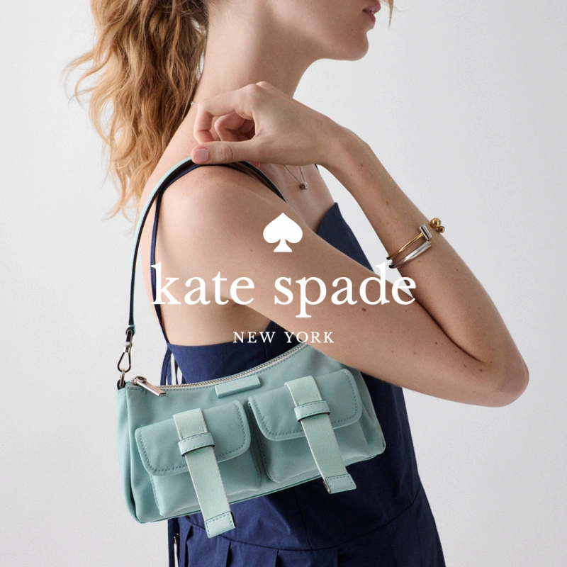 Redheaded woman wearing handbag from Kate Spade