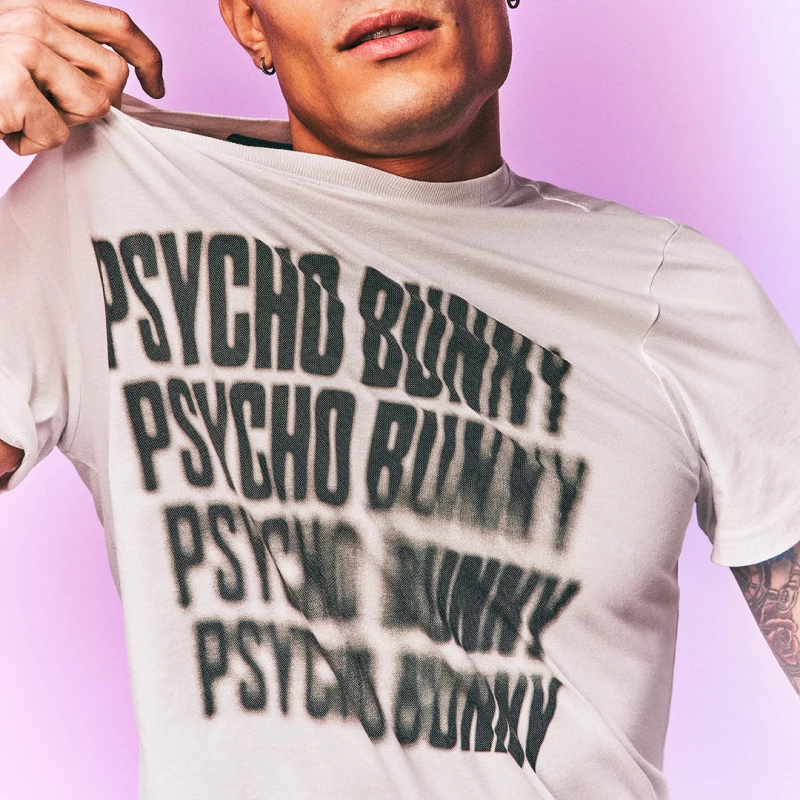 Man wearing Psycho Bunny shirt and pulling it