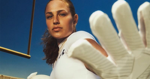 Athletic woman showing off gloves from under armour brand