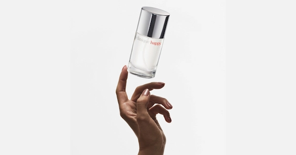 Hand touching a fragrance bottle floating