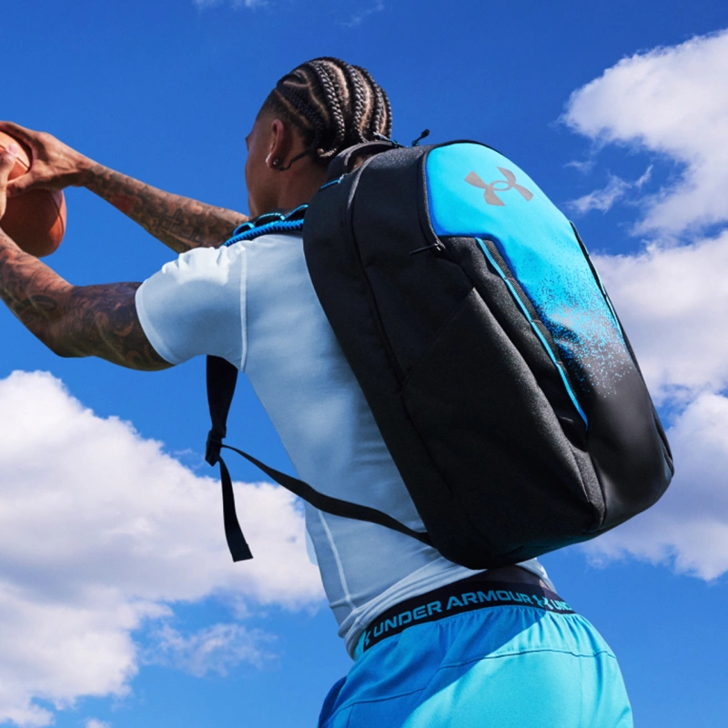 Athlete wearing Under Armour backpack catching football