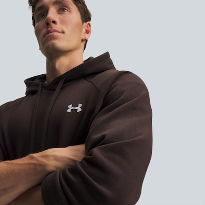 Man with brown Under Armour hoodie crossing arms