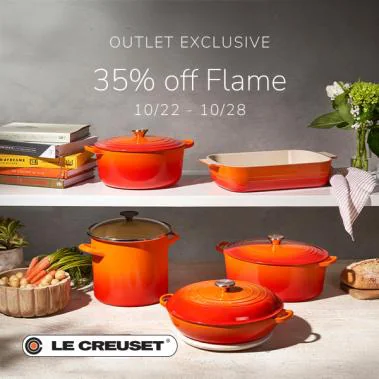 Le Creuset cookware in Flame orange on kitchen shelves