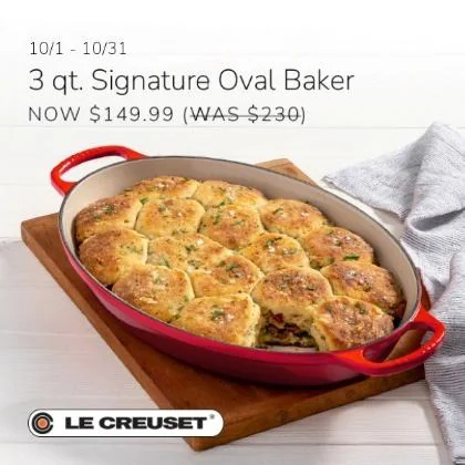 Red Le Creuset oval baker filled with baked biscuits