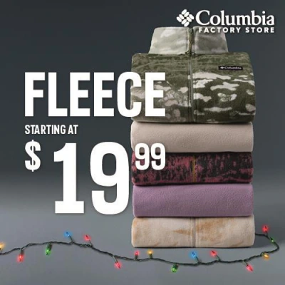Stack of folded fleece jackets with holiday string lights