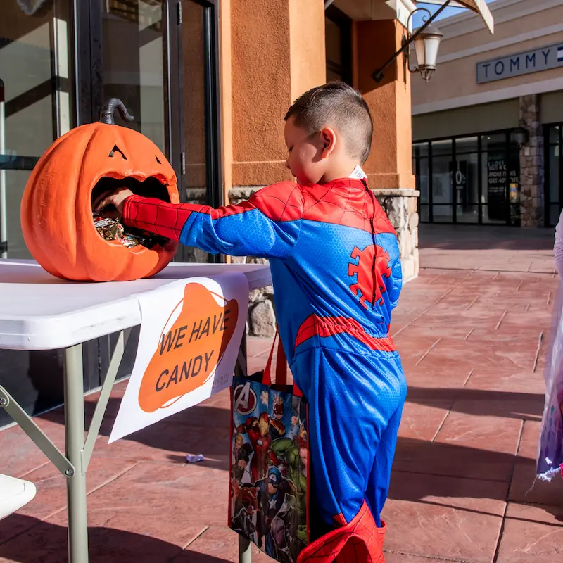 Child wearing spider man costume getting Halloween candy